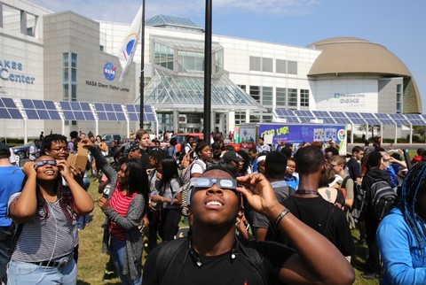 Students wear protective solar glasses to view eclipse in front of Great Lakes Science Center